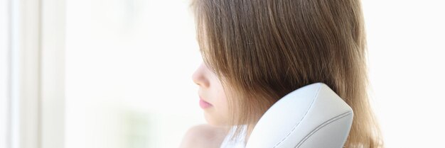 Closeup of little girl combing hair or making hairdo beauty and hair care childhood concept