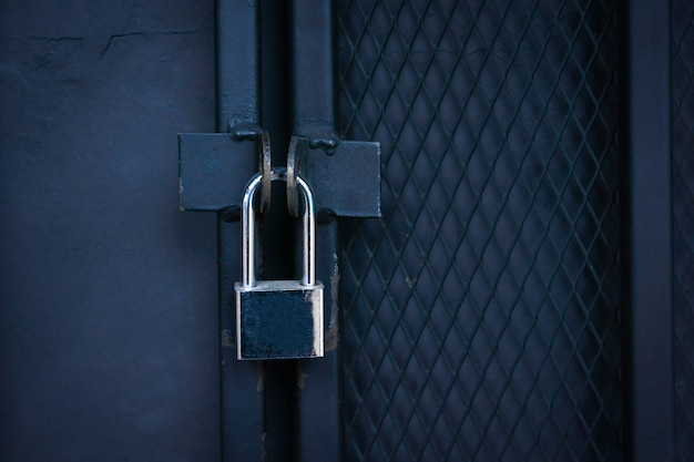 Photo closeup locked gate ,padlock on a metal iron gate.