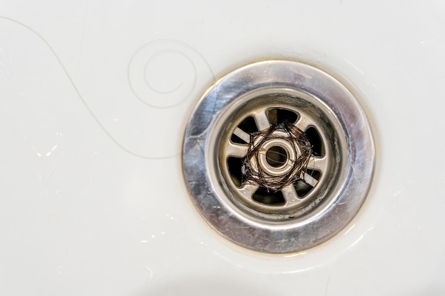 Closeup of long hair blocking the drain in the bathroom