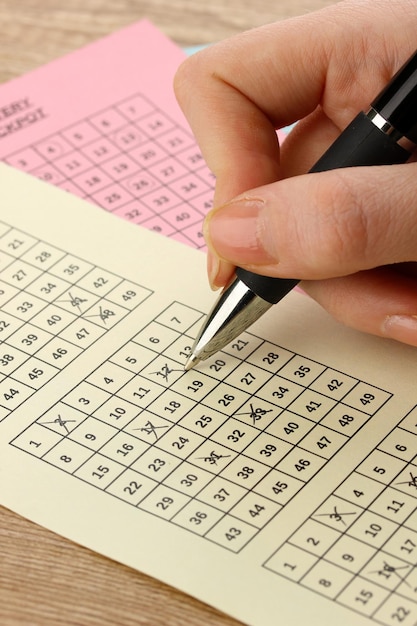 closeup of lotto ticket during the marking of numbers on wooden background