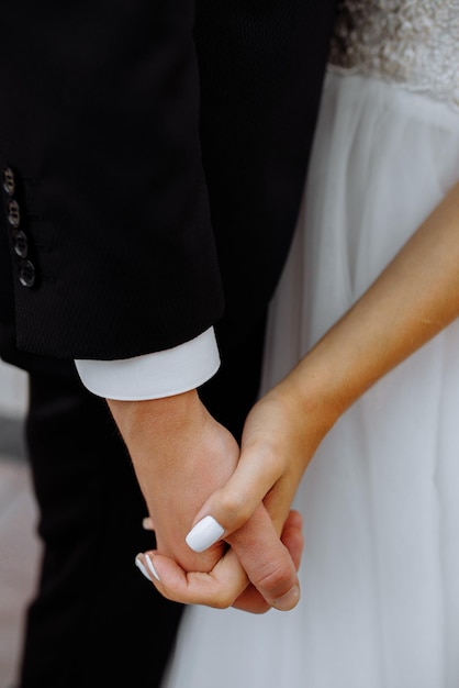 Closeup of loving couple holding hands while walking at sunset