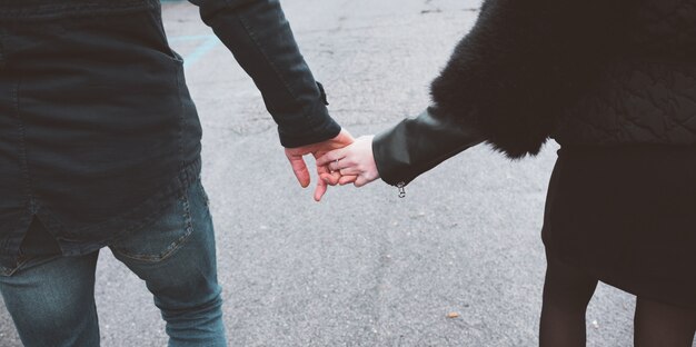 Foto primo piano di tenersi per mano delle coppie amorose