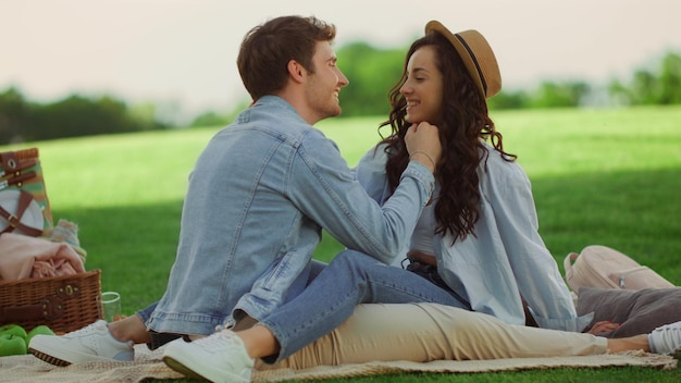 Closeup loving couple spending time on romantic dating at picnic Happy man and woman having picnic outdoors Romantic girl and guy sitting on blanket in park and love couple hugging on lawn