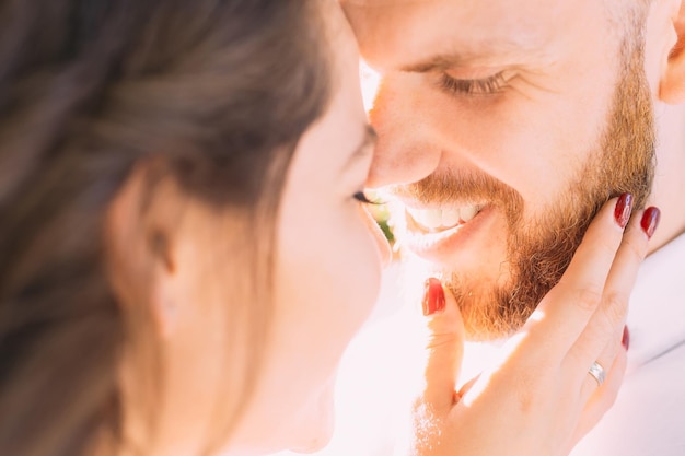 Closeup of a loving couple standing opposite each other with closed eyes Smile