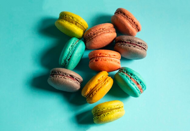 Closeup of macarons cakes of different colors in blue background Culinary and cooking concept Tasty colourful macaroons