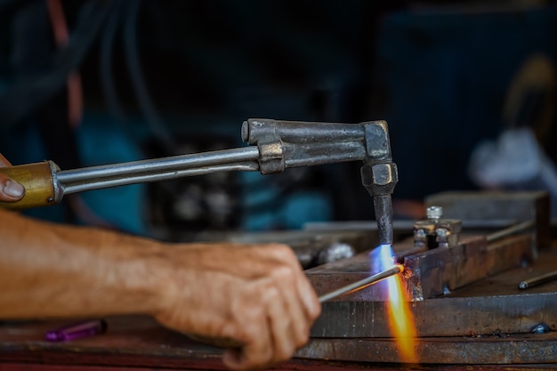 Closeup machinist hand bending the steel by torch  in metalworking factory