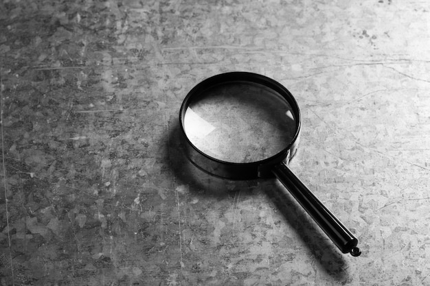 Closeup of magnifying glass on dark surface