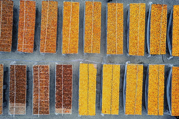 Foto close-up della produzione di persimmi secchi frutto di persimmo secco al sole trasformazione del persimmo asciugato