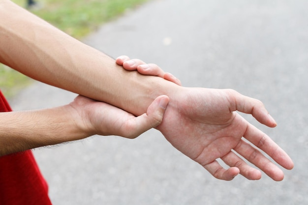 closeup of male arms holding her painful wrist because exercise
