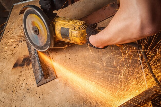 Closeup of a male construction worker cutting metal with a handheld circular saw