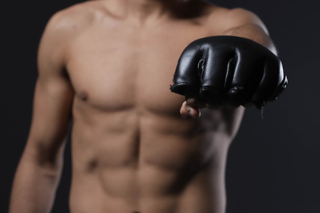 Mano maschio del combattente del primo piano con il guanto di mma pugno chiuso combattente prima di un combattimento o di un allenamento in una palestra sportiva.