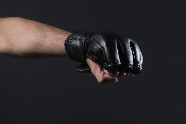 MMA 장갑으로 근접 촬영 남성 전투기 손입니다. 파이터는 스포츠 체육관에서 싸우거나 훈련하기 전에 주먹을 꽉 쥐었다.