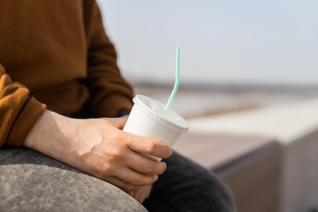 Closeup of male hand holding a paper coffee cup copy space