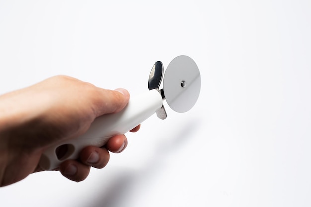 Closeup of male hand holding a pizza knife on white background