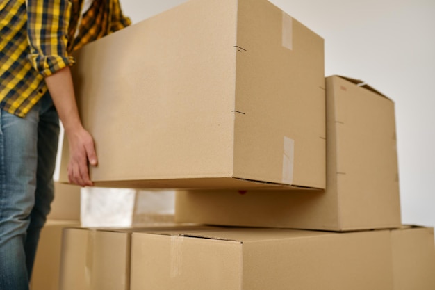 Closeup male hand lifting packed stuff in cardboard box. home
moving, housing and relocation