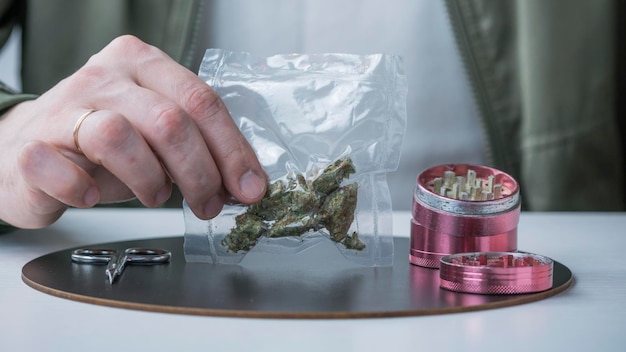 Closeup of male hands holding medical marijuana buds in vacuum\
seal bags