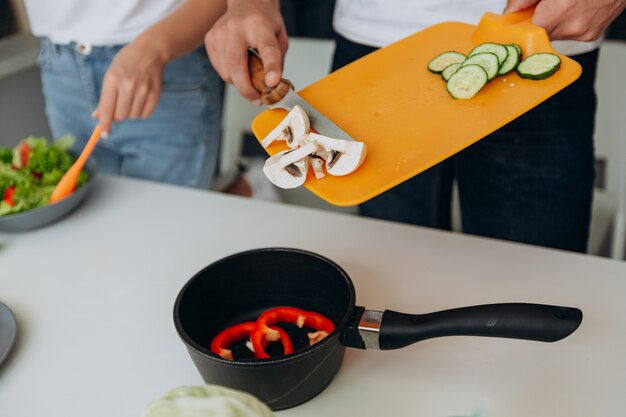 健康的な食品の準備中に野菜を持ってクローズアップ男性手