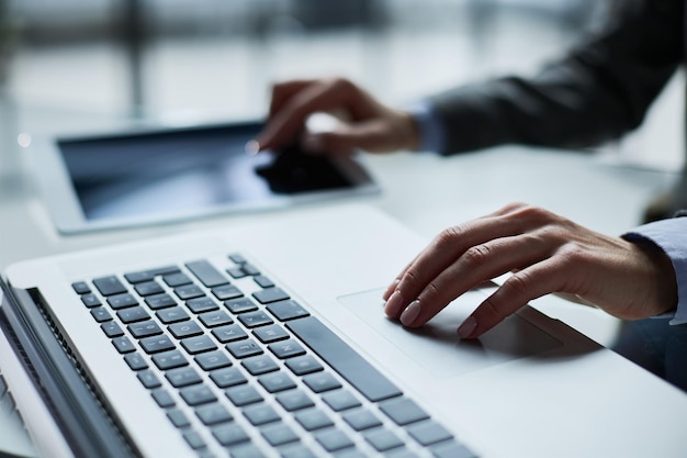 Closeup of male hands using laptop at office