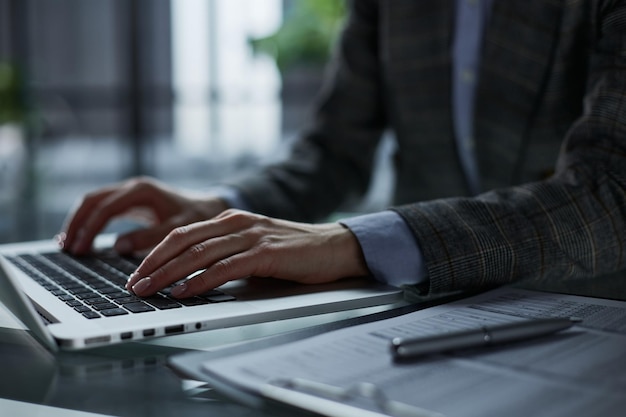 Closeup of male hands using laptop at office