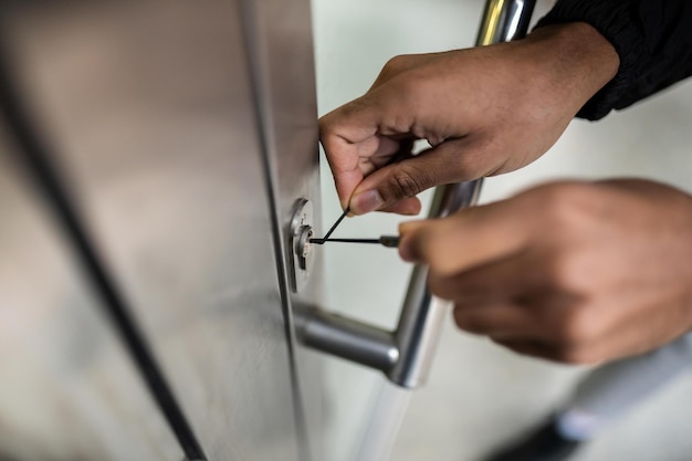 Photo closeup of male lockpicker fixing door handle at home