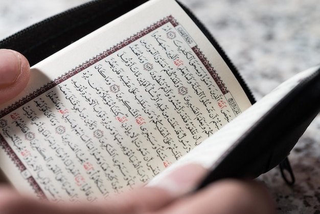Крупным планом мужчина-мусульманин, читающий Коран