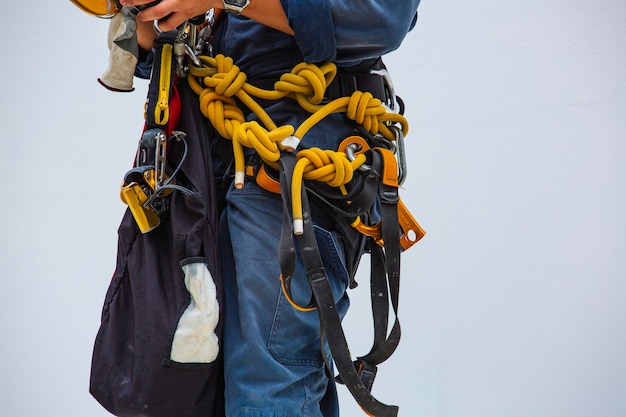 Closeup male worker standing on tank male worker height roof\
tank knot carabiner rope access safety inspection.