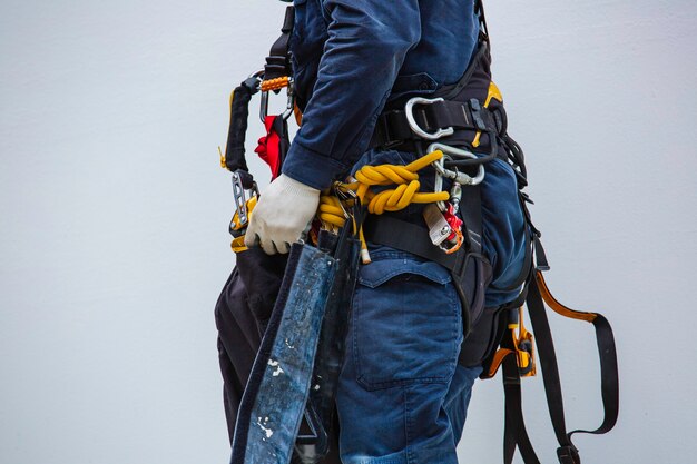 Closeup male worker standing on tank male worker height roof tank knot carabiner rope access safety inspection.