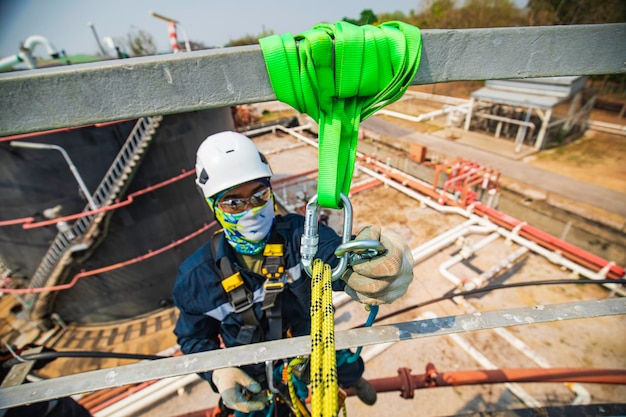 Closeup male worker standing on tank male worker height roof tank knot carabiner rope access safety