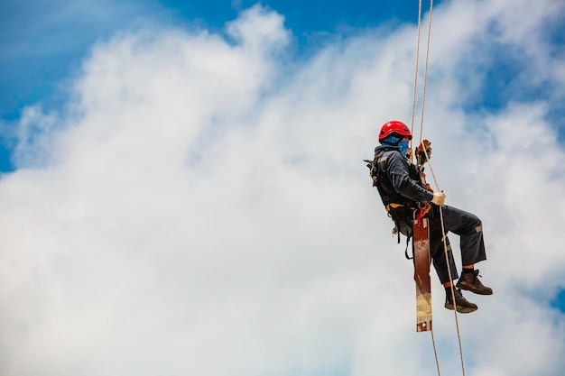 Closeup male worker swings on tank male worker height roof tank knot carabiner rope access safety