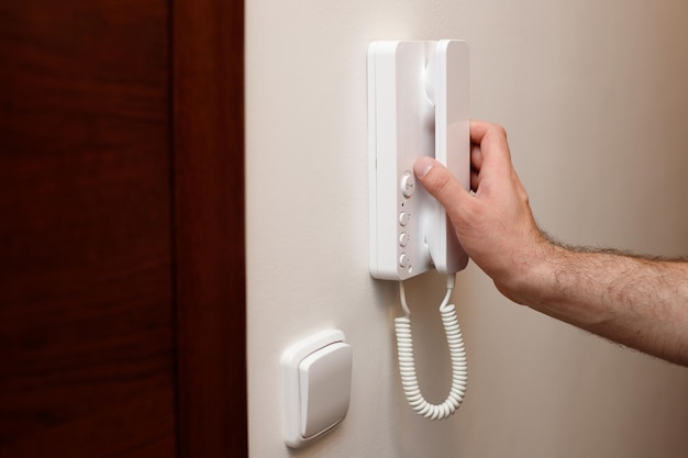 Closeup of a man answering the call to the intercom