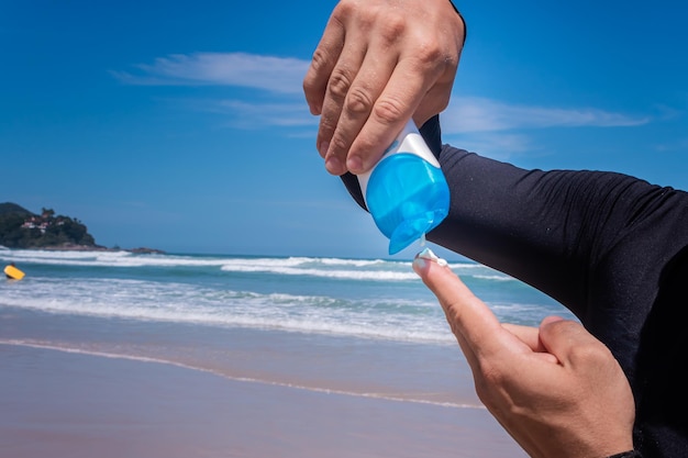 Closeup of man applying sunscreen on fingers.