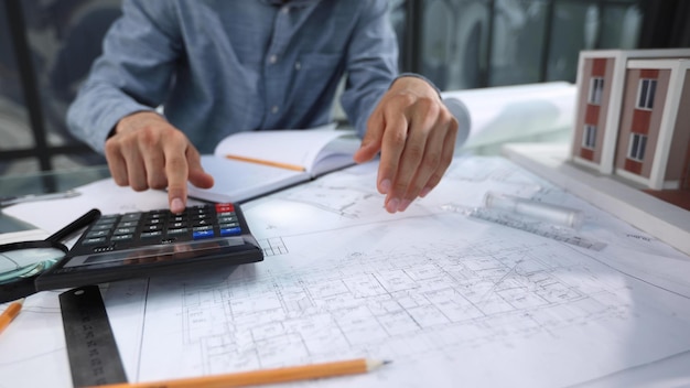 Closeup of man architect looking at blueprints in office