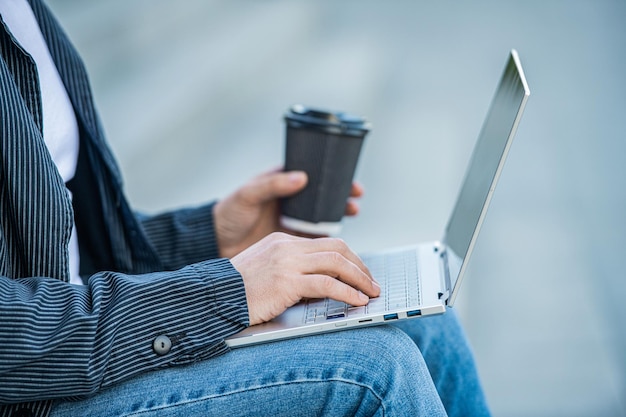 Closeup of man blogging online with pc outside photo of man blogging online with computer