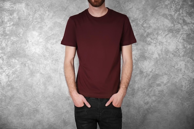 Photo closeup of man in claret red tshirt on colour textured wall background