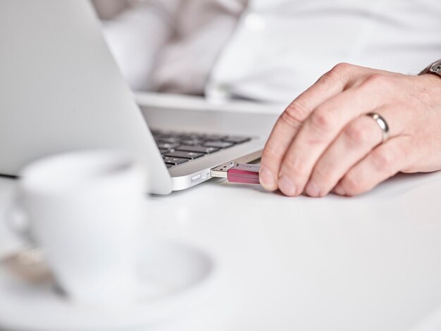 closeup of man connecting usb stick to laptop