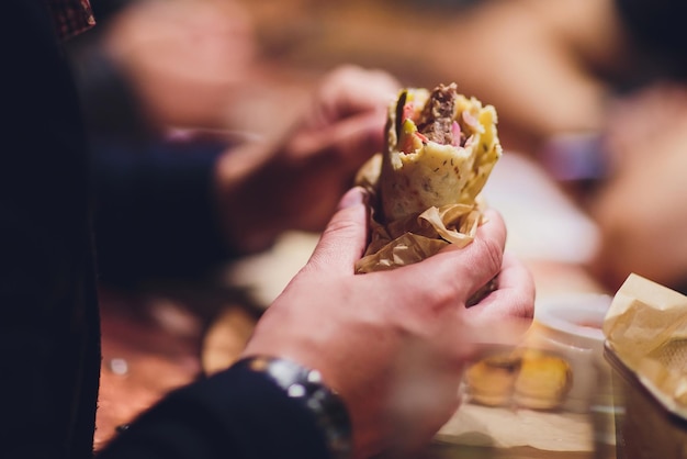 closeup of man eating doner kebab hand