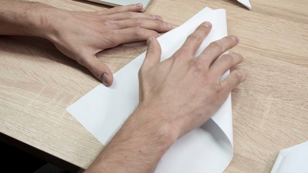 Closeup of man folding origami paper