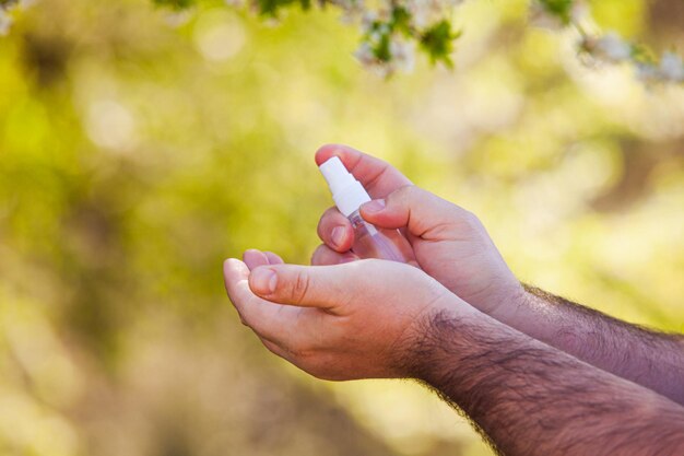 Closeup man hand met fles alcohol ontsmettingsmiddel en aan de andere kant sproeien Man zichzelf beschermen tijdens pandemie van coronavirus of covid19 Gezondheidszorg regels concept