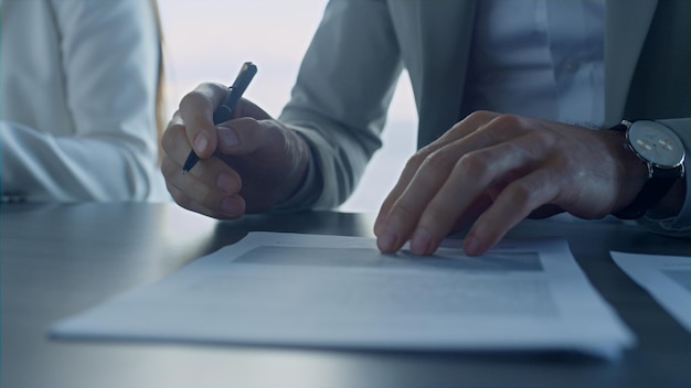 Closeup man hand signing contract in office Financial manager writing hold pen