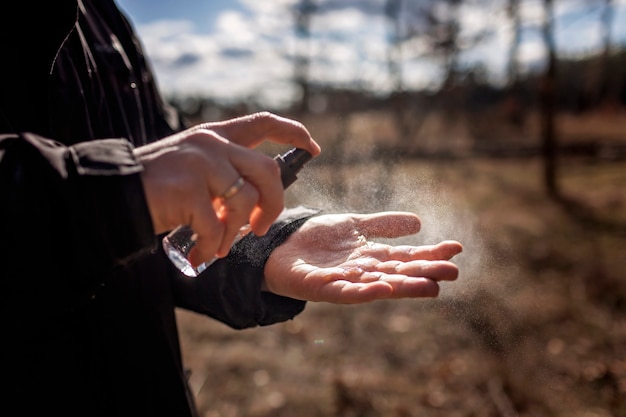 Photo closeup man hands applying alcohol spray or anti bacteria spray to prevent spread of virus