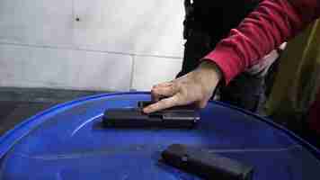 Photo closeup of a man hands holding and loading gun magazine in the pistol at the shooting range