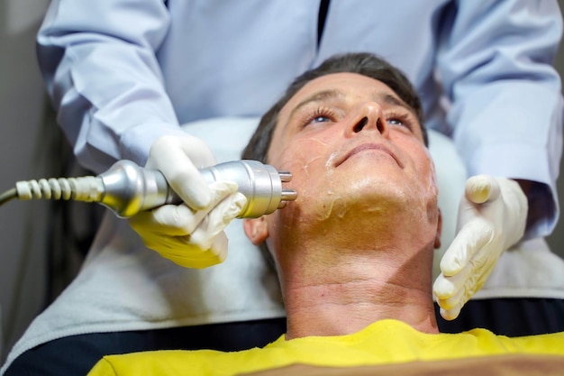 Closeup a man having therapy to stimulate facial skin and facial ultrasonic skincare treatment