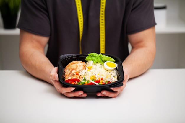 Closeup of a man holding a box full of protein rich foods for sports nutrition