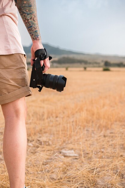 Closeup of a man holding a camera outdoors