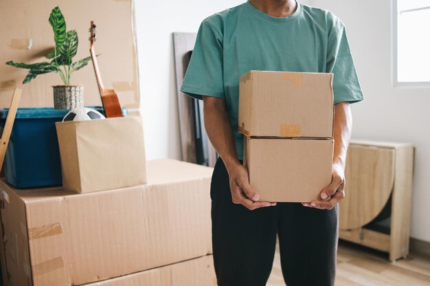 Photo closeup of a man holding stacked of carton boxes moving into new home