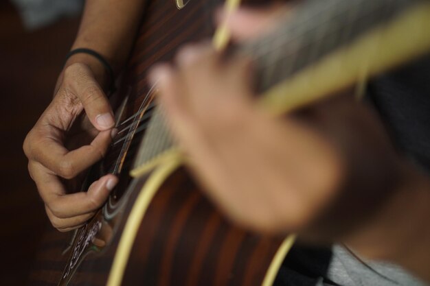 Closeup man playing acoustic guitar