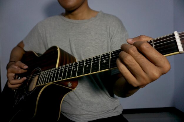 Closeup man playing acoustic guitar