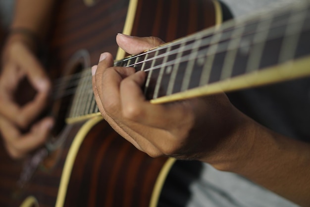 Closeup man playing acoustic guitar