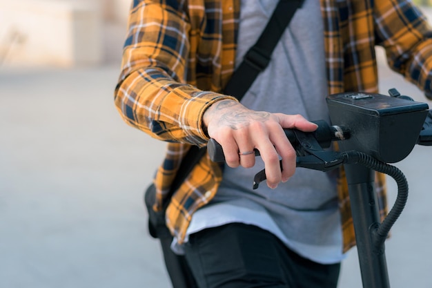 Closeup of a man riding an electric scooter on a street