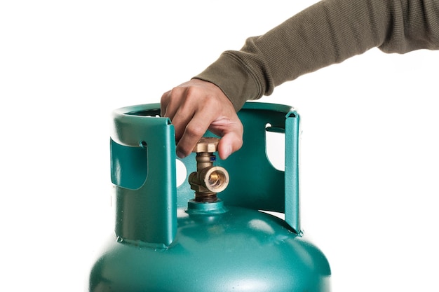 Крупным планом рука человека работает клапан баллона сжиженного нефтяного газа для приготовления пищи